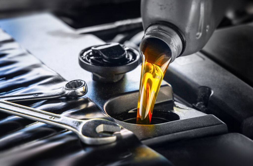 pour new automotive engine oil into the engine pour new automotive engine oil into the engine